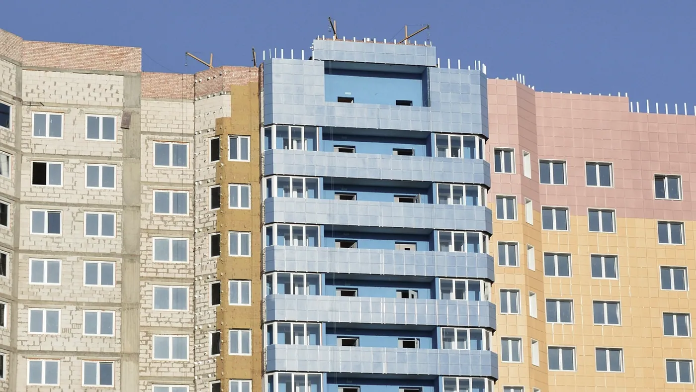An ETICS façade mid-installation with the mesh coat being applied