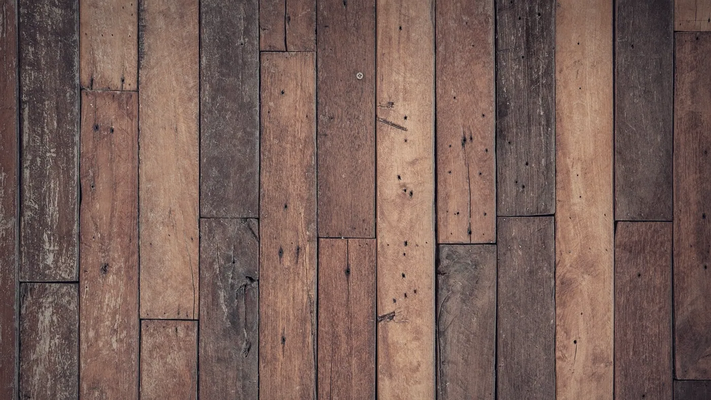 Two laminate planks under raking light, one scuffed and one pristine